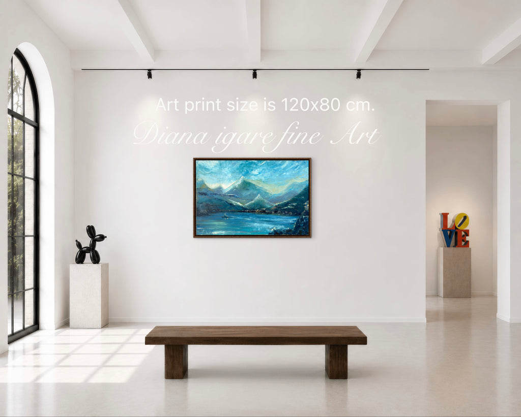 A framed landscape art print depicting blue mountains and a lake, displayed on a white gallery wall in a modern art space with a wooden bench below. Text overlays indicate the print size is 120x80 cm.