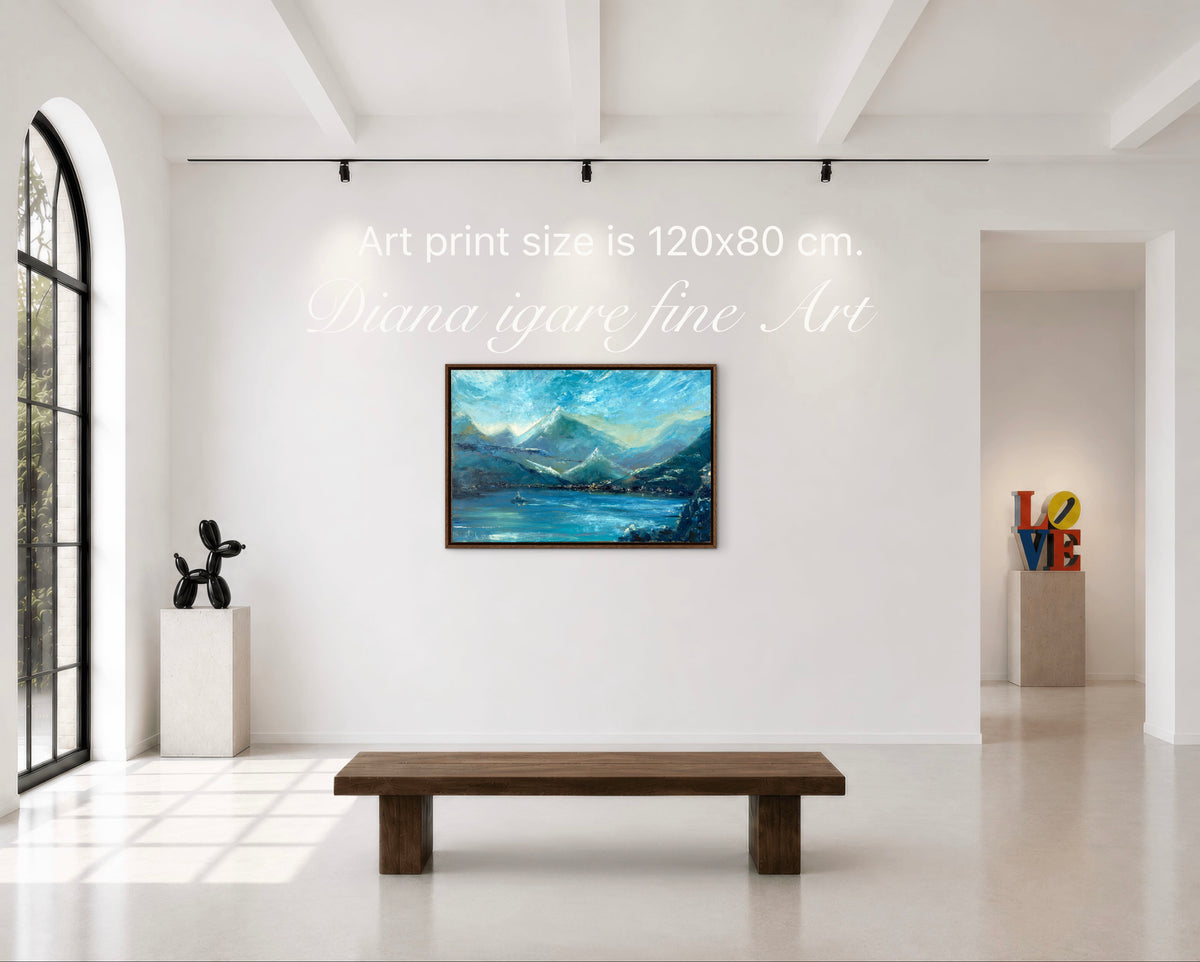 A framed landscape art print depicting blue mountains and a lake, displayed on a white gallery wall in a modern art space with a wooden bench below. Text overlays indicate the print size is 120x80 cm.