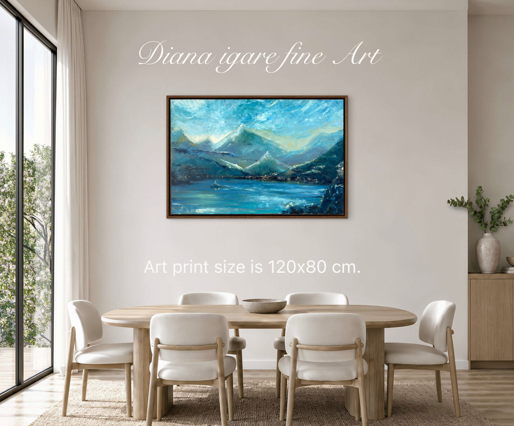 A framed landscape art print depicting blue mountains and a lake, displayed on a beige wall in a dining room setting with a wooden table and chairs. Text overlays read 'Diana igare fine Art' and 'Art print size is 120x80 cm.