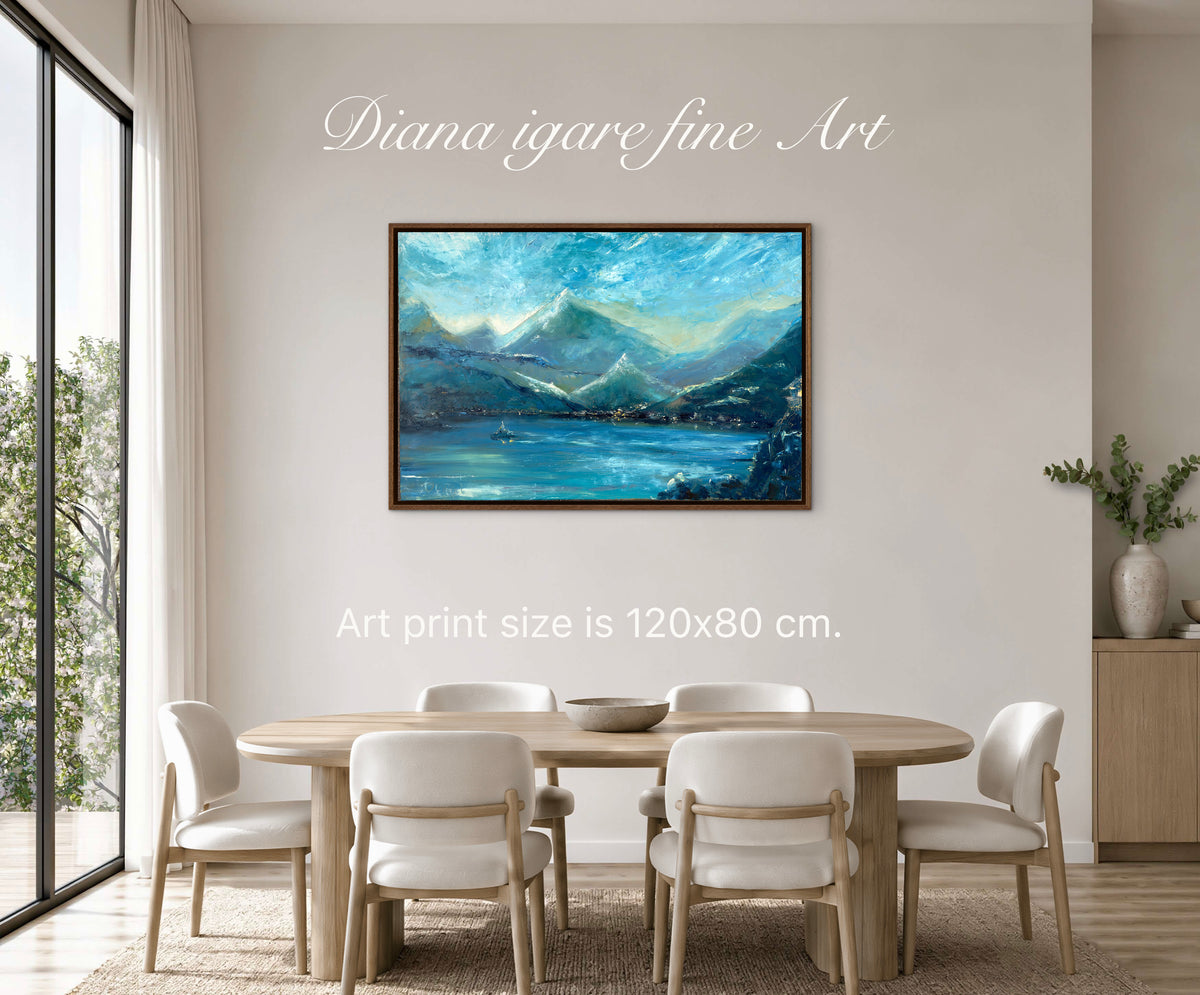 A framed landscape art print depicting blue mountains and a lake, displayed on a beige wall in a dining room setting with a wooden table and chairs. Text overlays read 'Diana igare fine Art' and 'Art print size is 120x80 cm.