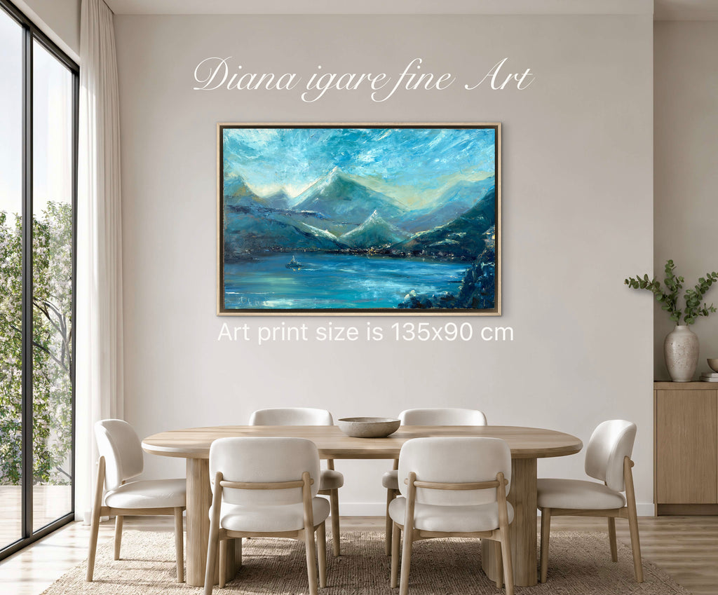 A framed landscape art print depicting blue mountains and a lake, displayed on a beige wall in a dining room setting. White text overlays read 'Diana igare fine Art' and 'Art print size is 135x90 cm'.