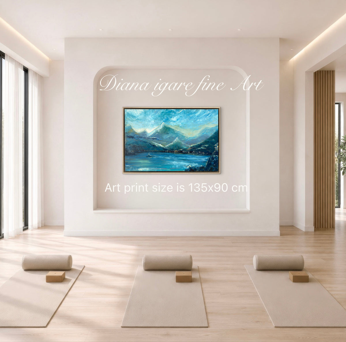 A framed landscape art print depicting blue mountains and water, displayed on a white wall in a bright, modern yoga studio. The text 'Diana igare fine Art' and 'Art print size is 135x90 cm' is overlaid on the image.