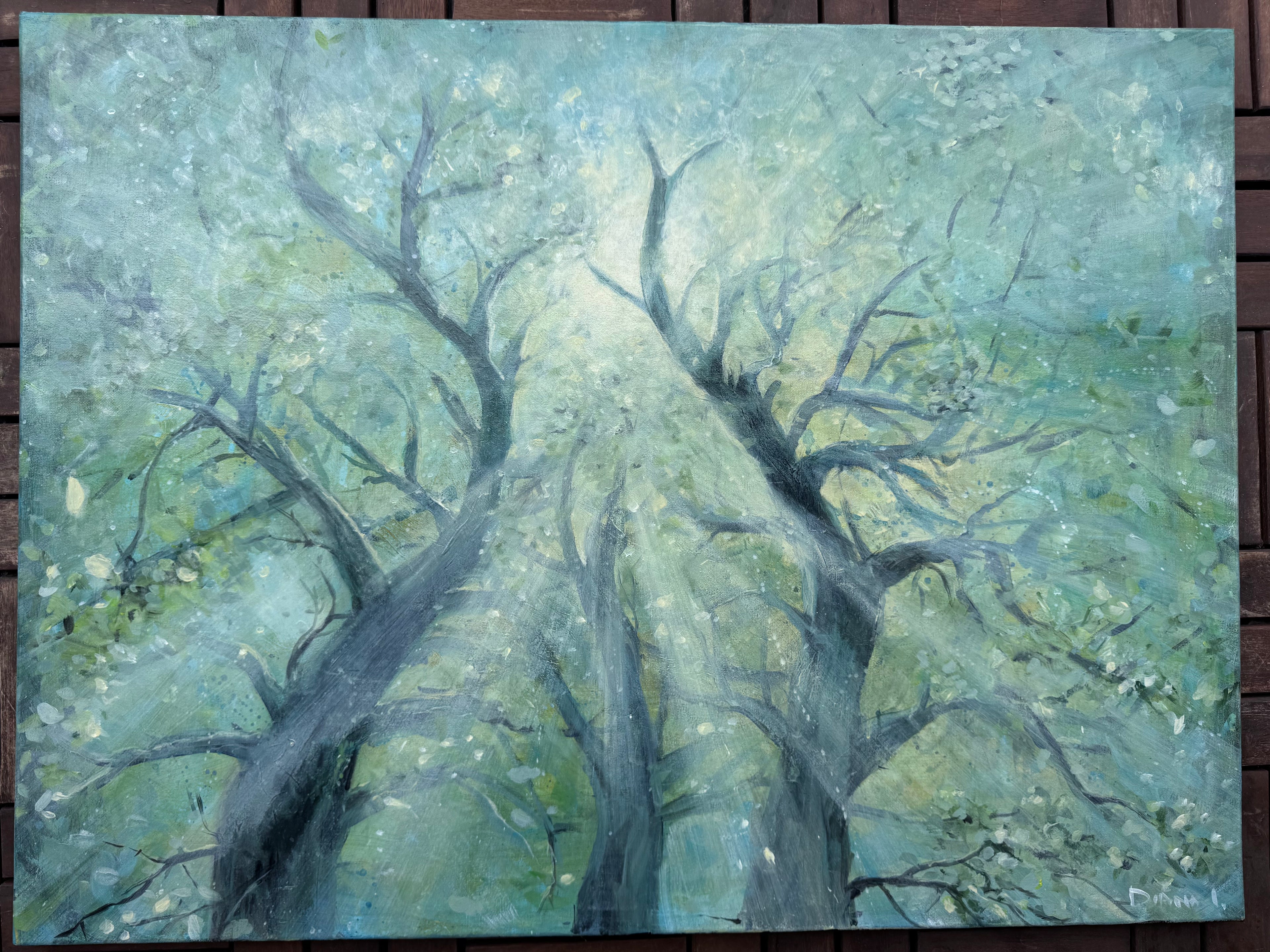An impressionistic painting of leafless trees with light rays filtering through, rendered in shades of blue, green, gray, and white, displayed on a dark wooden background.
